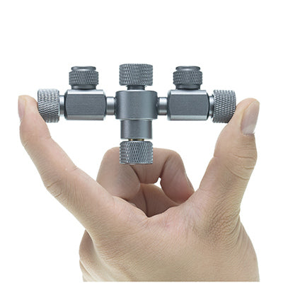 A small metallic aquapro co2 splitter 2 way aquarium system held between a person's fingers.
