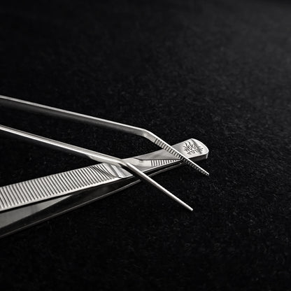 weekaqua Pair of curved tweezers on a black textured background